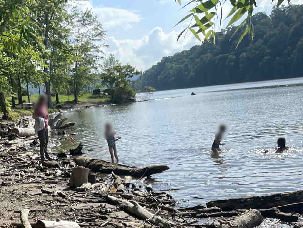 Children play at unmaintained Cheat Lake’s Millstone Point Beach on June 16, 2025, amid alleged neglect by owners Eagle Creek Renewable Energy